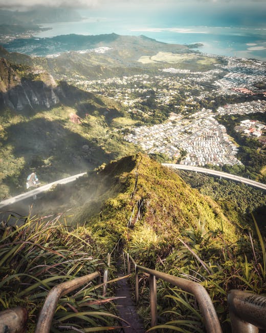 A breathtaking aerial view of Haiku Stairs with lush mountains and cityscape in Oahu, Hawaii.