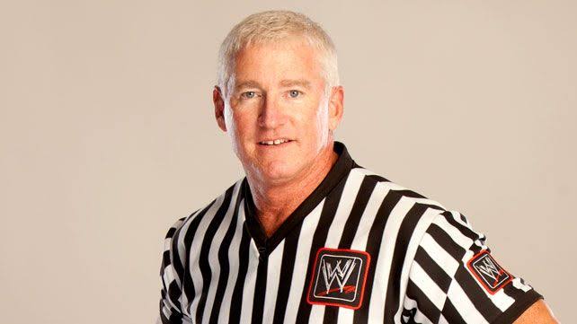 Scott Armstrong, a former wrestler and current WWE referee, in a striped shirt.